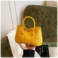 Chic yellow tote bag in suede and leather finish featuring a metal circular clasp - Yellow