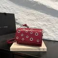 Burgundy faux leather crossbody bag with silver metal eyelets and accordion pleats - One Size / Red