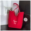 Detail of red canvas tote bag featuring white Beyou Merci typography and contrast stitching - One Size / Red