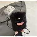 Close-up of black fuzzy monster bag with thick pink lips on grey suit jacket - Black