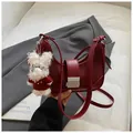 Deep red crescent shoulder bag in leather and suede with a cute white puppy pendant - Red with Pendant