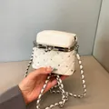 Detail of white quilted mini bag with crystal studs and silver kiss-lock metal frame - White