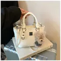 Creamy white bucket bag with a cute teddy bear charm and silver hardware accents - With Pendant / White