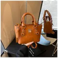 Chic brown orange leather bucket bag with silver hardware and adjustable shoulder strap - With Pendant / Brown