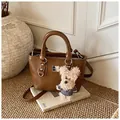 Dark brown textured bucket bag with a plush bear charm and adjustable shoulder strap - With Pendant / Coffee