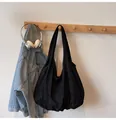 Minimalist large black canvas tote bag hanging with headphones for daily commuting - One Size / Black