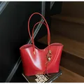 Detail van rode waxleren shopper met hartjeshangers op een donkere houten trap - Met Hanger / Bordeauxrood