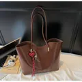 Bruine tote bag van oliewasleder met rode hartvormige hanger en minimalistisch merk - Met Hanger / koffiekleur