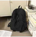 Detail of a large black nylon backpack with a drawstring front pocket and side mesh pouch - One Size / Black