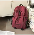 Detail of burgundy water-resistant nylon backpack with drawstring pocket and buckles - One Size / Red