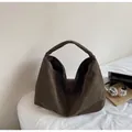 Grande borsa tote minimalista in pelle scamosciata marrone scuro in un contesto moderno - Verde
