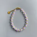 Détail du bracelet en perles violettes avec cristaux et un pendentif coeur doré - Style de perles rondes violettes et perles transparentes facettées / Taille unique / 17+3cm / Violet