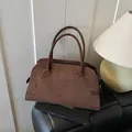 Deep brown matte suede tote bag with slim cylindrical handles and elegant side buckle detail - Coffee