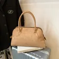 Classic camel faux suede tote bag with round handles on a silver travel suitcase - Yellow Brown
