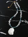 Detail van een blauwe kralenketting met een witte schelphanger en gouden sluiting - Zuivere Gebroken Steen Stijl / 38+5cm / Hemelsblauw