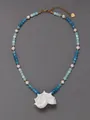 Detail van schelphanger ketting met blauwe stenen en witte parels op grijze achtergrond - Natuurlijke Vierkante Steen Stijl / 38+5cm / Blauw