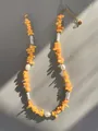 Detailed shot of handmade beaded necklace with natural stones, pearls and gold extension chain - Orange Yellow Crushed Stone Style (8)