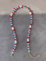 Detail van kleurrijke kralenketting met parels, turkoois stenen en gouden karabijnsluiting - Rood Blauw Kralen Stijl