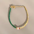 Detailed macro of a gold plated beaded bracelet with green and yellow natural stones - Yellow Green Spliced Beads with Pearl