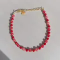 Close-up of pink and red beads with 18K gold plated steel lobster clasp and logo tag - Red Pink Translucent Beads with Gold Spacers