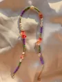 Dettaglio di perline colorate e pietre irregolari su tessuto di seta champagne - Stile Perline Miste Multicolore