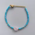 Detailed macro view of beaded bracelet with blue crystals and pink stone on grey background - Sky Blue Cut Beads with Pink Frosted Bead