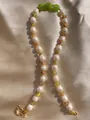 Détail d'un collier artisanal avec perles vertes, perles d'eau douce et motifs floraux - Collier de Perles Rondes à Fleurs Vertes 17 / 43cm