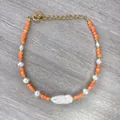 Detailed macro of 18K gold beaded bracelet with orange stones and baroque pearls - Orange Cut Beads with Baroque Pearl