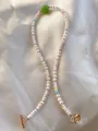 Detail van kralenketting met zoetwaterparels, gekleurde glaskralen en gouden OT-sluiting - Groene Ronde Kralen en Parelketting 19 / 43cm