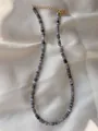Detail van handgemaakte kralenketting met 18k gouden sluiting op satijnen stof - Zwart Grijs Wit Kolom Stijl (7)