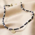 Detalle de collar de cuentas con piedras naturales y un colgante de oro martillado - Estilo Colgante Disco Redondo de Cuentas Blanco y Negro