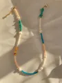 Close-up of handmade beaded necklace with turquoise and pearls on textured fabric - Turquoise Agate Style (18)