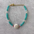 Detail view of handmade beaded bracelet with blue faceted stones and gold lobster clasp - Lake Blue Cut Beads with White Accent