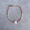 Close-up of beaded bracelet with pink natural stones and a white heart-shaped pendant - Pink Beads with Heart Pendant