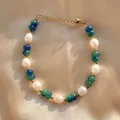 Detail van een 18K vergulde kralenarmband met witte parels en groenblauwe edelstenen - Blauwgroene Kralen met Onregelmatige Parel