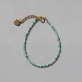 Detail van groene kralenarmband met gouden tussenstukken en hartvormige verlengketting - Gefacetteerd Groen (2)