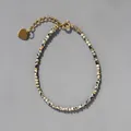 Détail du bracelet en pierres avec pendentif cœur doré et chaîne de réglage - Blanc Tacheté (11)