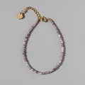Detail of beaded bracelet with purple faceted stones, gold extender chain and heart charm - Purple