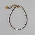 Detail of beaded natural stone bracelet with 18k gold plated heart charm and lobster clasp - Beige