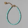 Close-up of sky blue faceted beads bracelet with gold lobster clasp and heart pendant - Light Blue