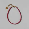 Detailed shot of red faceted beads bracelet with gold heart pendant and lobster clasp - Bright Red