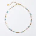 Vue détaillée du collier de perles et pierres bleues avec pendentif cœur doré - Ras du cou en titane avec perles d'eau douce et pierres bleu clair