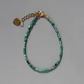 Gros plan de perles vertes à facettes avec un pendentif cœur doré sur un bracelet boho - Ton Vert Facetté (37)
