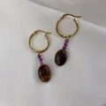 Detail of gold hoop earrings with purple beads and tiger eye stone on white silk background - Purple Faceted Bead with Tiger Eye Style