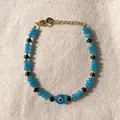 Dettaglio del bracciale con perline blu, ciondolo Evil Eye e chiusura dorata - Stile Malocchio Perline di Vetro Blu Trasparenti (25SL1-28) / 17+3cm