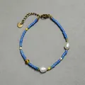 Detailed macro view of colorful glass beads and natural freshwater pearls on a gold chain - High Saturation Blue Glass Round Bead Style (12)