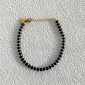 Dettaglio del bracciale con pietre nere opache e chiusura a moschettone dorata regolabile - Stile Perline Cilindriche Nero Opaco (25SL1-38) / 17+3cm
