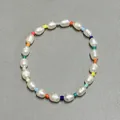 Detailed top view of a handmade bracelet with white baroque pearls and colorful glass beads - Multicolor Spacer Baroque Pearl Style (13)