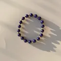 Detail van handgemaakte kralenarmband met blauwe natuurstenen en gouden metalen kralen - Donkerblauwe Lapis Lazuli Textuur Stijl (7)