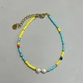 Macro shot of colorful glass beads with freshwater pearls and gold lobster clasp - Yellow Blue Seed Bead Center Double Pearl Style (21)